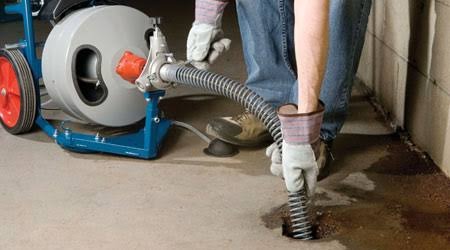 Licensed Houston drain technician operating heavy motorized sewer cable auger in Houston, TX 77002